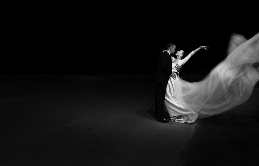 Она танцует в белом платье смотрит тайно. Свадебный танец. Невеста на темном фоне. Белый танец. Свадебные фотосессии темный фон.